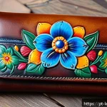 가죽공예 커스텀 제품 - A close-up view of a handcrafted leather wallet featuring intricate hand-painted floral designs in v...